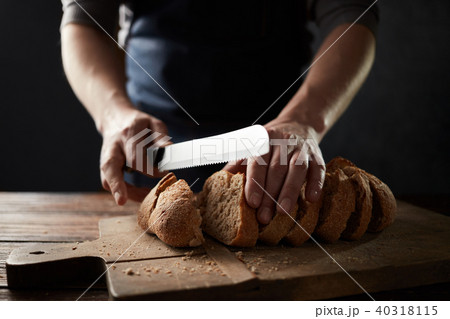 grain bread put on kitchen wood plate with a chef holding knife for cut grain bread put on kitchen wood plate with a chef holding knife for cut 40318115