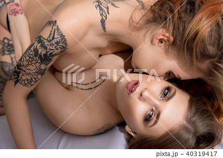 Tattooed sexy women lying in bed high angle shot Tattooed sexy women lying in bed high angle shot 40319417