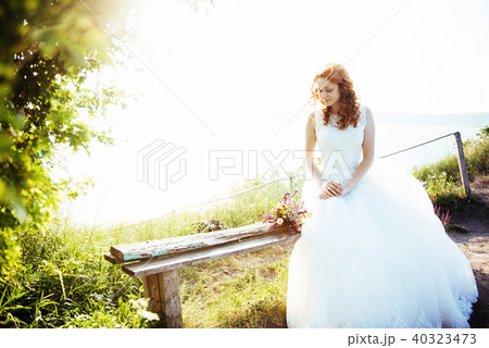 bride with a bouquet of flowers near the water 40323473