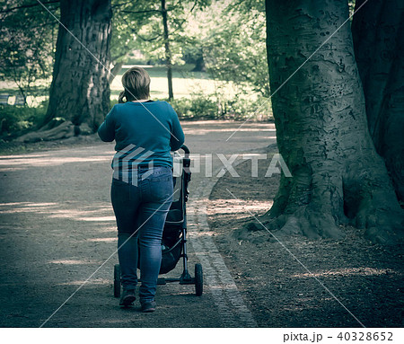 Sized mother walking with baby stroller 40328652