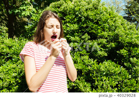 unhappy woman with napkin sneezing in green park unhappy woman with napkin sneezing in green park 40329028