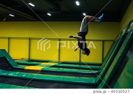 trampoline jumper performs acrobatic exercises on the trampoline trampoline jumper performs acrobatic exercises on the trampoline 40330527
