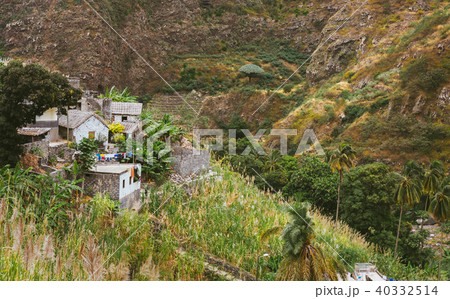 Local stone houses of small village between lush green vegetation and mountain landscape. Santo 40332514