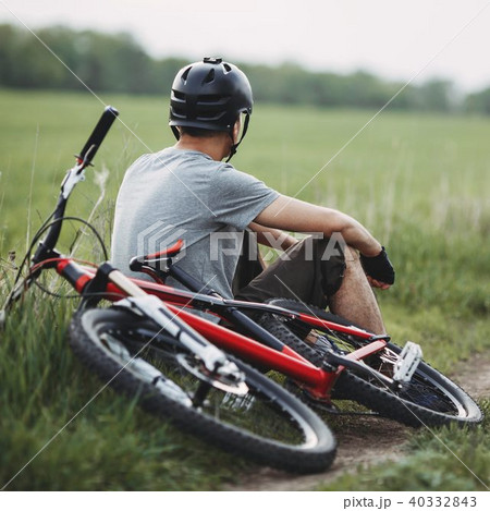 Man resting sitting at the roadside with bicycle Man resting sitting at the roadside with bicycle 40332843