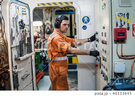 Marine engineer officer controlling vessel engines in engine control room ECR Marine engineer officer controlling vessel engines in engine control room ECR 40333645