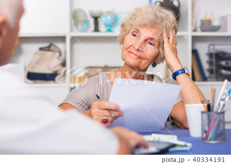 Upset senior woman discussing with husband bills Upset senior woman discussing with husband bills 40334191