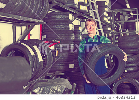 Portrait of mechanic man with auto tires in workshop Portrait of mechanic man with auto tires in workshop 40334213