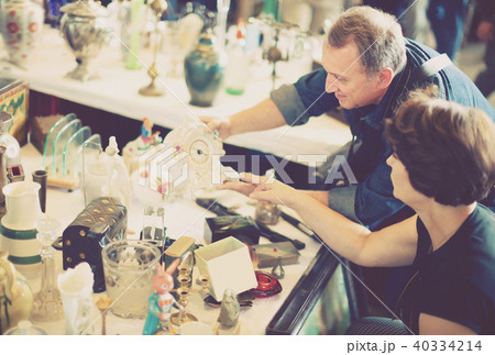 Mature tourists study the range of flea market Mature tourists study the range of flea market 40334214