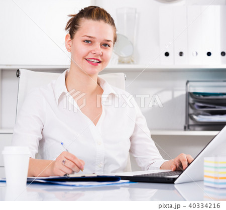 Young office worker is working with documents and laptop Young office worker is working with documents and laptop 40334216