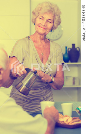 Happy senior woman pouring tea Happy senior woman pouring tea 40334349