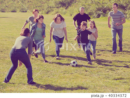 Smiling males and females kicking the ball Smiling males and females kicking the ball 40334372