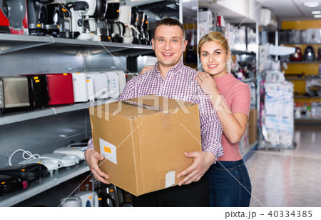 Couple with packed purchases in household appliances section in shop 40334385