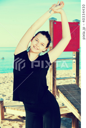 Female in black T-shirt is practicing stretching Female in black T-shirt is practicing stretching 40334430