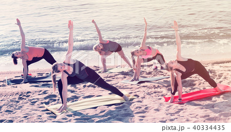 Group of young females performing yoga 40334435