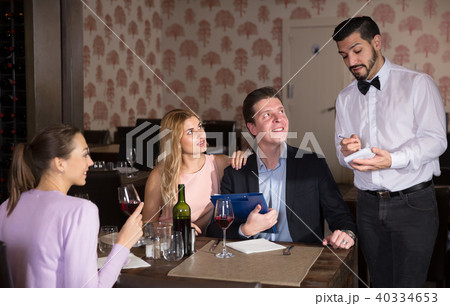 Confident waiter taking order in restaurant 40334653