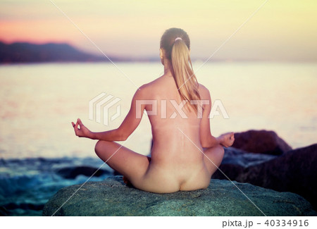 Positive naked sportwoman meditating in padmasana Positive naked sportwoman meditating in padmasana 40334916