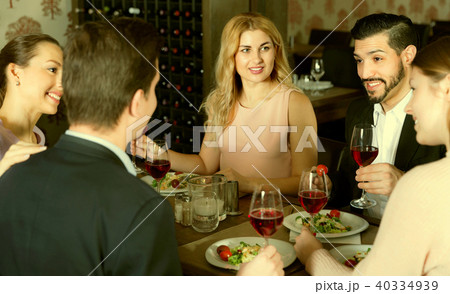 Сheerful friends having dinner and drinking red wine in restaur 40334939