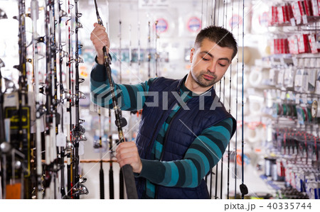 fisher selecting fishing rod 40335744