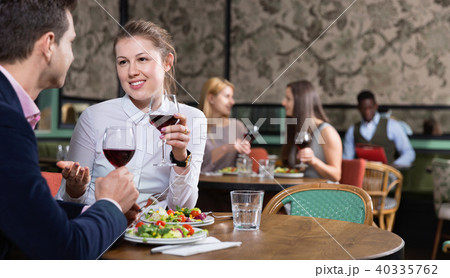 Attractive girl with boyfriend enjoying dinner with wine in cozy restaurant 40335762