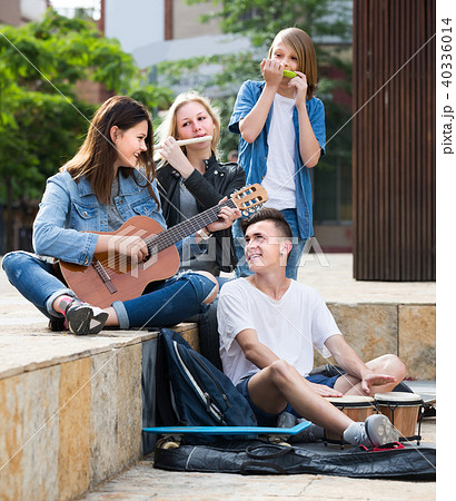 Portrait of four teenagers playing music together outdoors 40336014