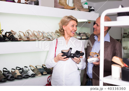 Mature couple picking shoes in boutique. 40336360