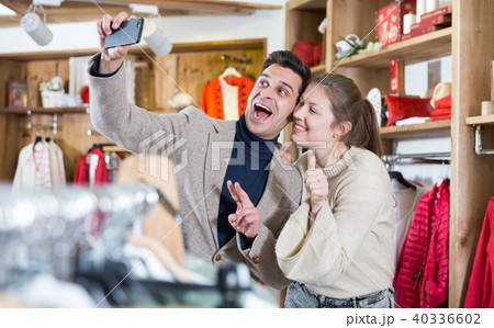 Smiling couple is satisfied of purchases and taking selfie 40336602