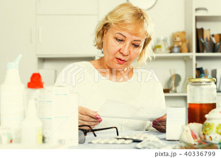 Mature woman with medicines and bills 40336799