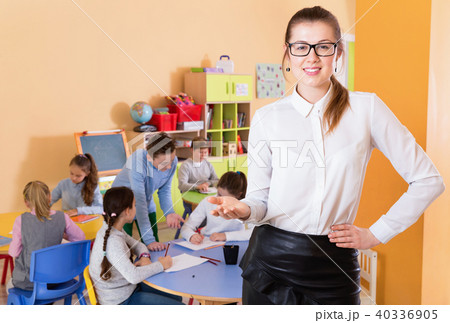 Portrait of friendly young female teacher standing in classroom 40336905