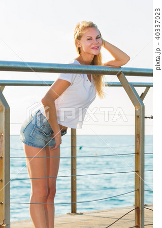 Cheerful female is posing playfully on pirce in her free time 40337023