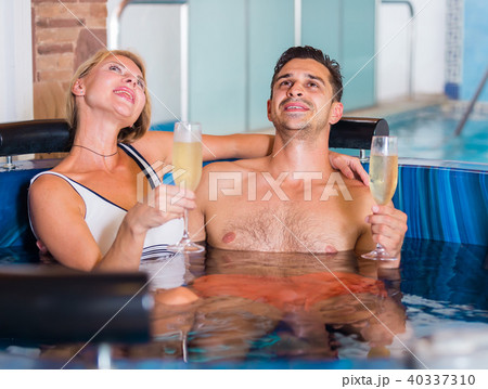 Couple is drinking champagne while resting Couple is drinking champagne while resting 40337310