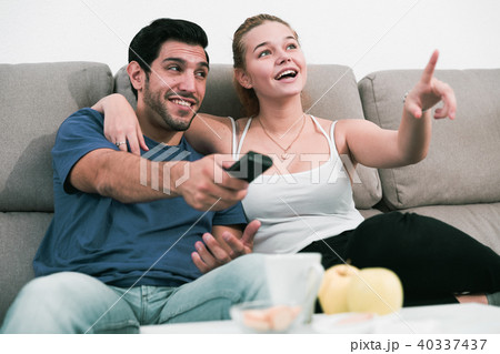 Loving couple on sofa watching TV Loving couple on sofa watching TV 40337437