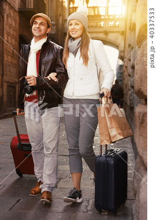 Man and woman walking at the historical streets with bags in aut 40337533