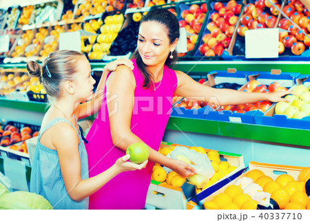 Mother with girl picking apples in shop Mother with girl picking apples in shop 40337710