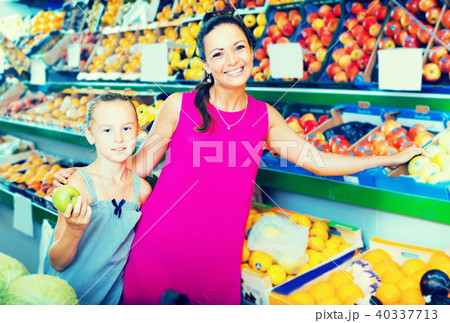 Happy family of woman with daughter buying apples 40337713