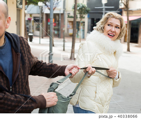 Portrait of frightened adult woman and robber Portrait of frightened adult woman and robber 40338066