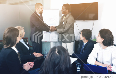Two businessmen shaking hands as sign of closing deal Two businessmen shaking hands as sign of closing deal 40338971