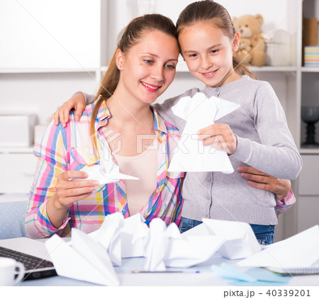 Woman and girl making airplanes of pape 40339201