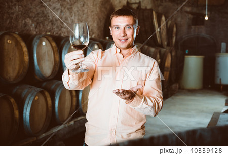 man with glass of wine in winery cellar. man with glass of wine in winery cellar. 40339428