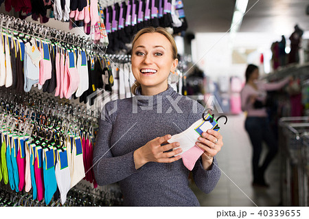 female customer holding different pair of socks in hands in underwear store female customer holding different pair of socks in hands in underwear store 40339655