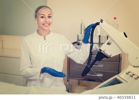 Woman doctor displaying machine for laser hair removal Woman doctor displaying machine for laser hair removal 40339811