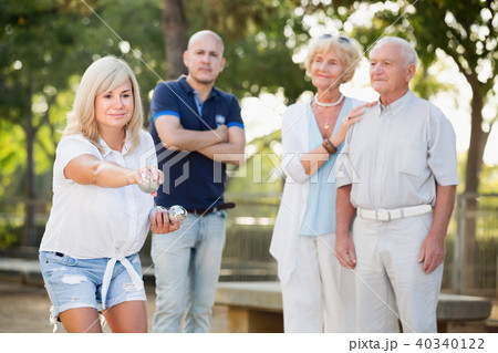 Smiling mature woman and friends playing petanque Smiling mature woman and friends playing petanque 40340122