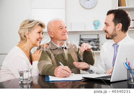 Old man and woman sign sale agreement 40340231
