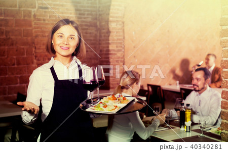 woman waiter demonstrating restaurant to visitors 40340281