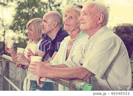 mature people with plastic cup standing in the park 40340333