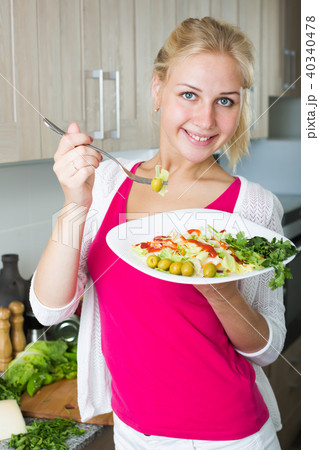 Portrait of cheerful blond girl eating salad Portrait of cheerful blond girl eating salad 40340478