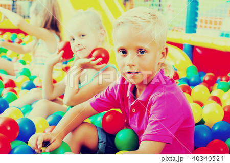 Boy sitting and playing with multicolored plastic balls 40340524