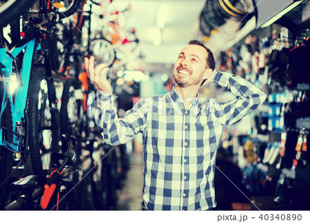 Biker is choosing in sports store convenient bike Biker is choosing in sports store convenient bike 40340890