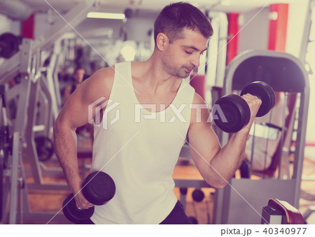 Man exercising with dumbbells in gym 40340977