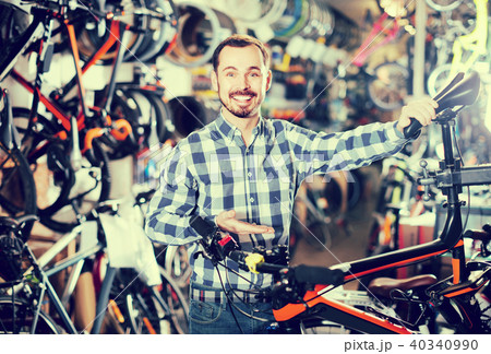 man checks bicycle handlebar in shop when choosing bike 40340990