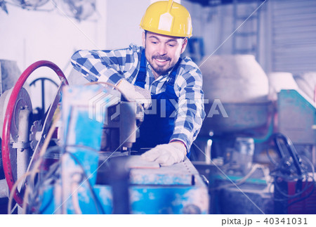 Adult guy is using disk saw to cut tile Adult guy is using disk saw to cut tile 40341031